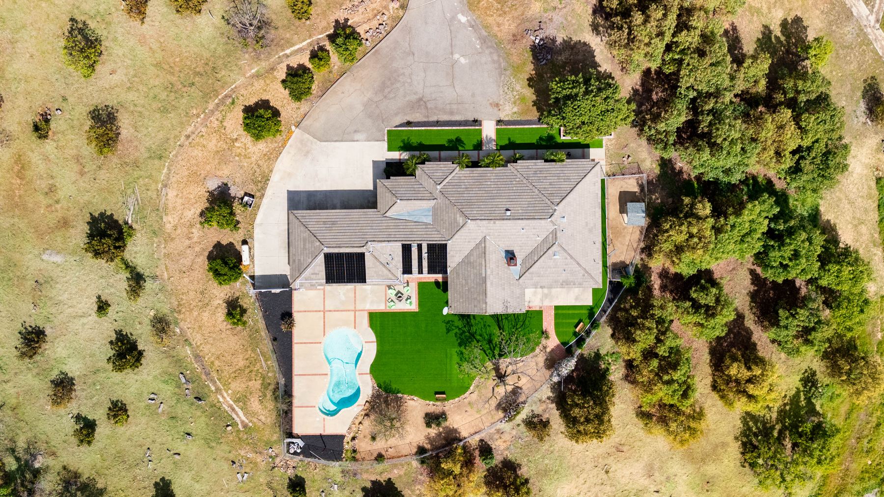 Aerial view of the property, pool, and surrounding hills