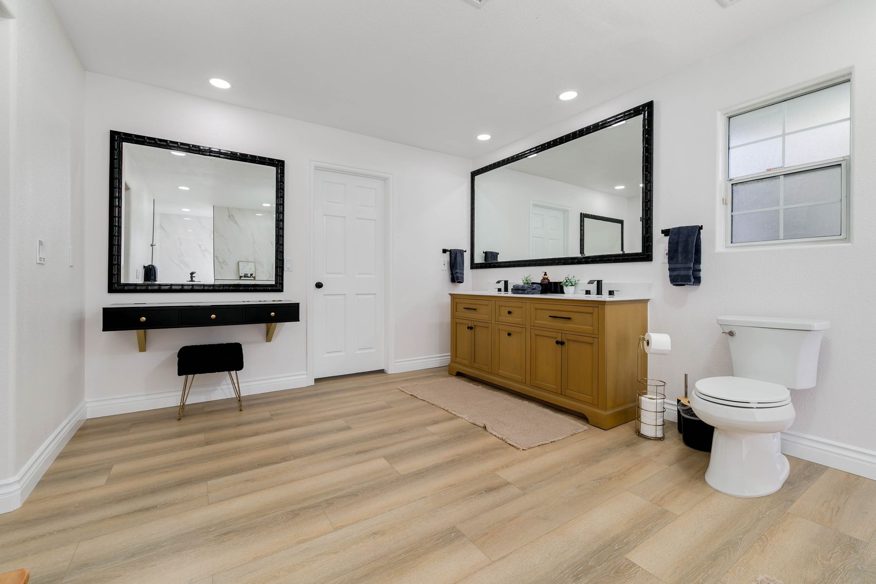 Primary bathroom with mustard vanity and black-framed mirror